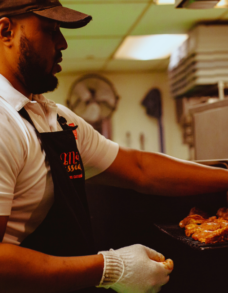 a man in a kitchen preparing food on a pan