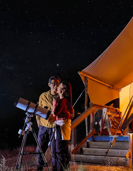 a man and woman standing in front of a tent