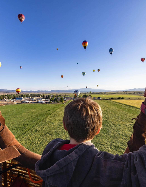 two people watching hot air balloons in the sky