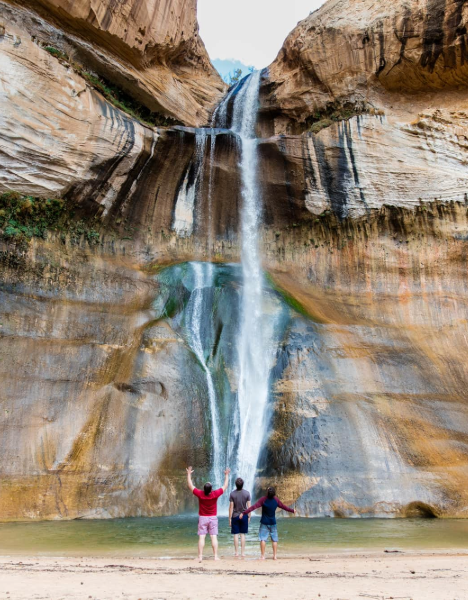 a couple standing in front of a waterfall