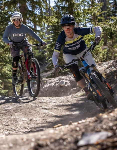 two people riding bikes on a rocky trail