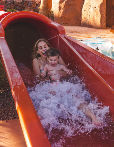 a woman and a child in a water slide