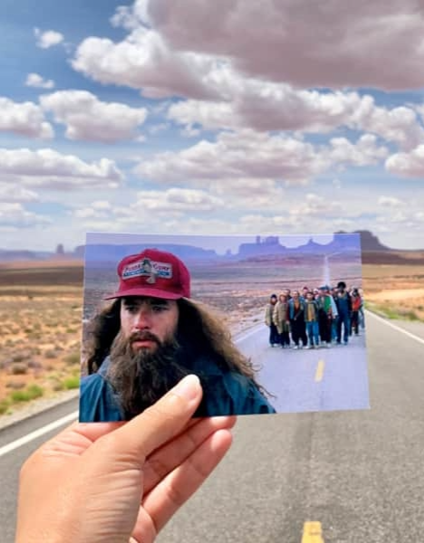 a person holding up a photo of a man on the road