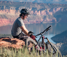 a man sitting on top of a mountain with a bike
