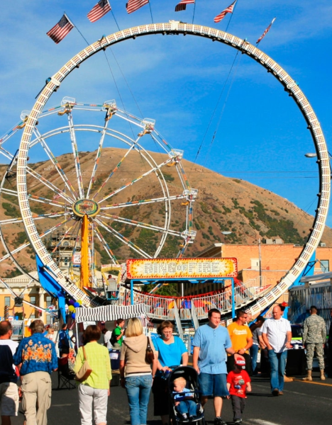 a crowd of people walking around a carnival