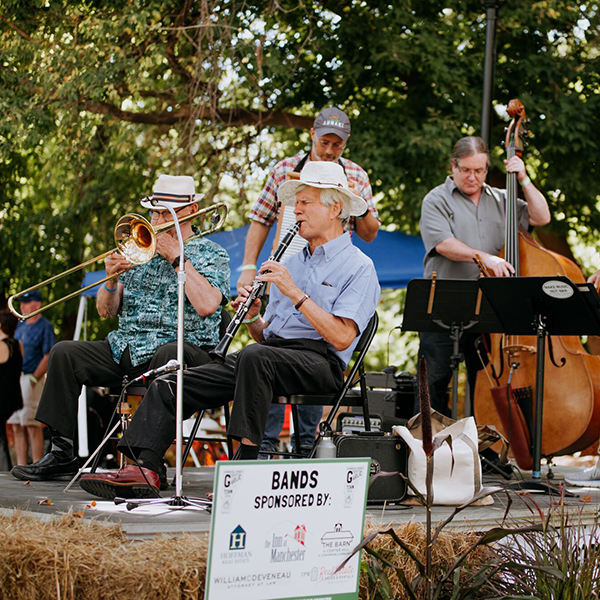People enjoy live music at an outdoor festival in the early fall.
