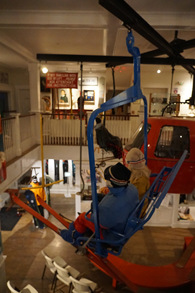 The inside of a museum on skiing and snowboarding, featuring equipment and posters on the walls and lots of color.&nbsp;