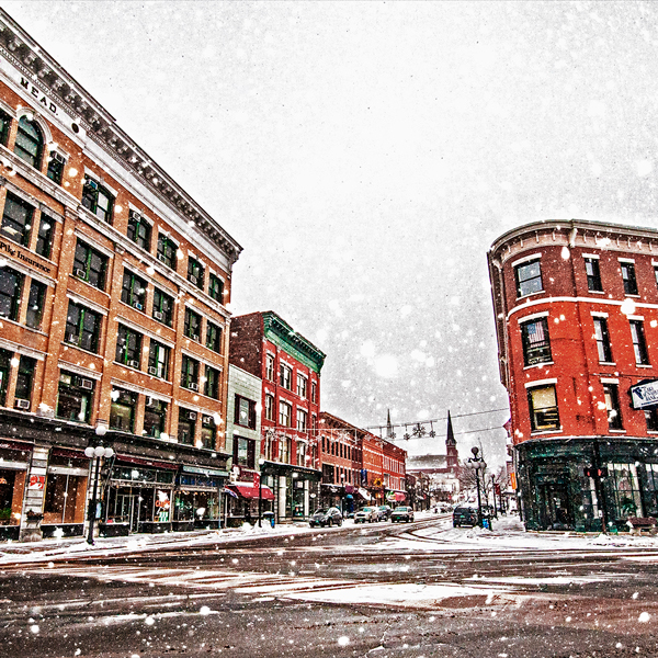 A historic downtown in the winter with snow flying.