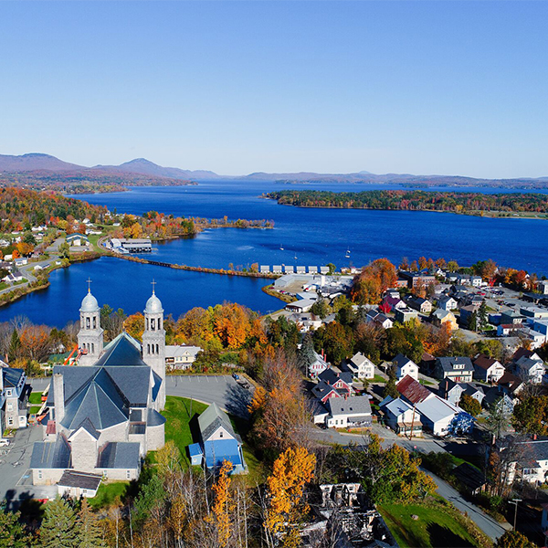 Seen from above, a historic downtown in the fall with stone architecture and a lake nearby.&nbsp;