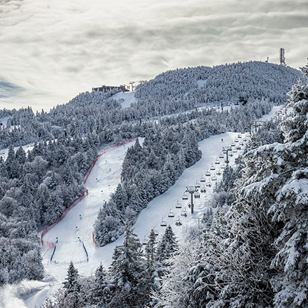 Seen from above, a ski resort with groomed trails on a winter day.&nbsp;
