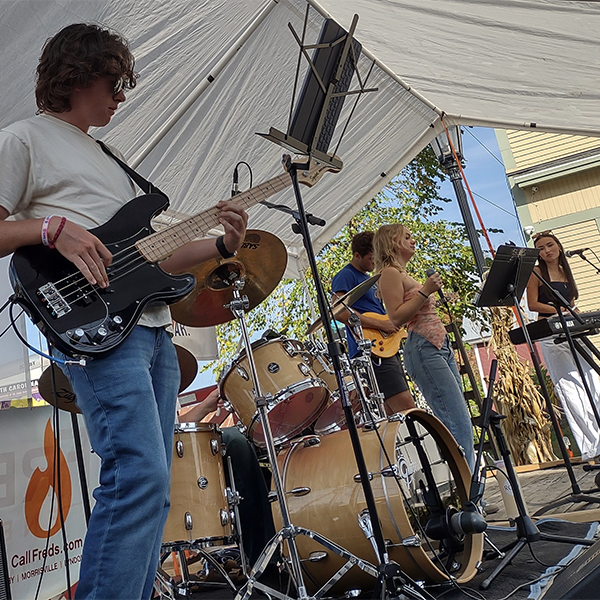 On stage, a band performs seen close-up.&nbsp;