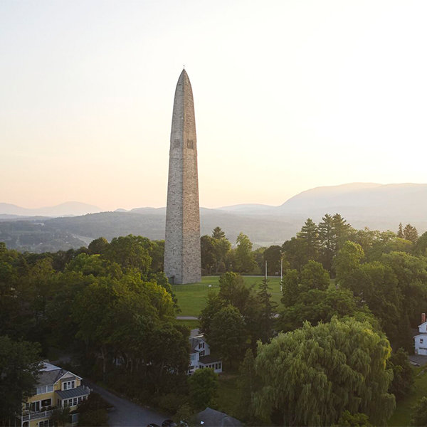 A large stone monument seen from afar on a sunny summer day.