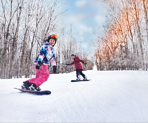 two people snowboarding down a ski hill 