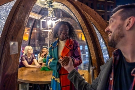 woman invites man into igloo for dinner with friends