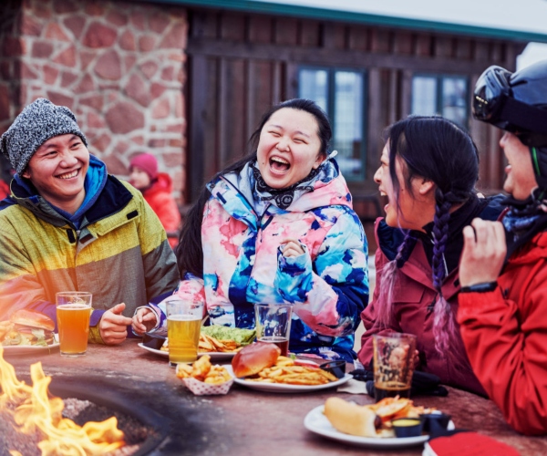 friends enjoying a meal after spending time outdoors in the snow