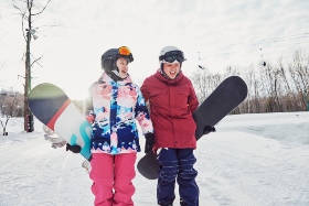 two friends walking with their snowboards