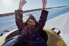 little girl sledding down tubing hill 