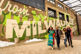 friends laughing and having a good time looking at outdoor graffiti