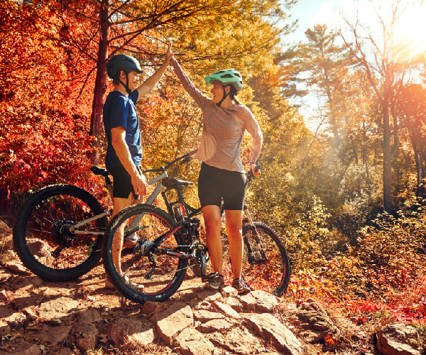 couple giving each other a high five while stopped with their bikes 