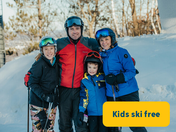 family posing for a photo on a ski hill 