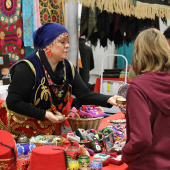 women shopping at vendor booth during holiday folk fair international 