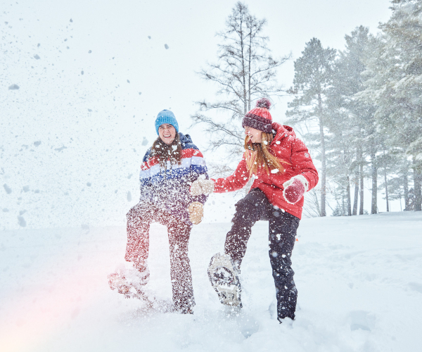 two girls playing in the snow while snowshoeing 