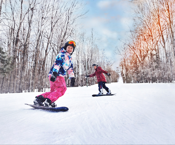two people snowboarding down a ski hill 