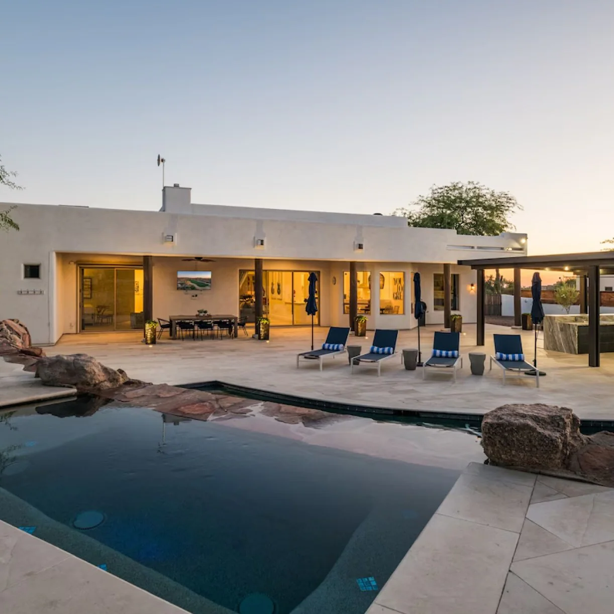 A modern ranch home with a large pool 