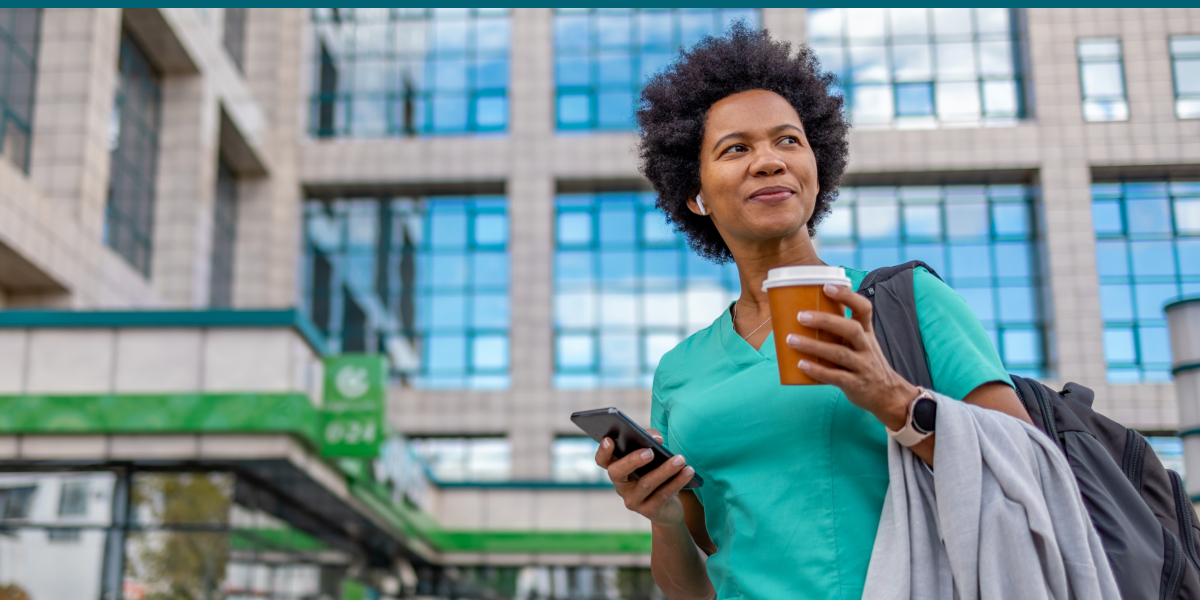 Woman Standing in Front of an Office Building holding a coffee and phone 