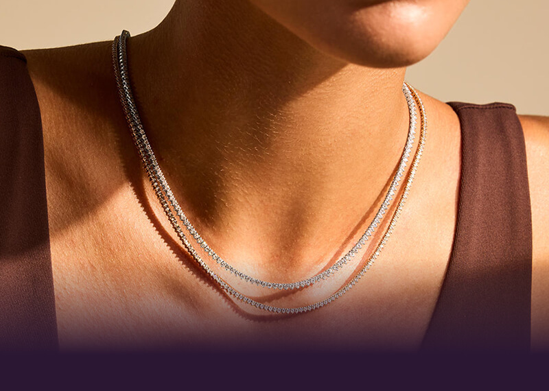 Woman close up her neck showcasing beautiful Necklaces.