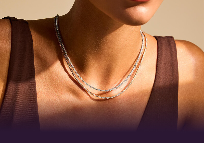 A woman close up, showcasing her beautiful Tennis Necklaces.