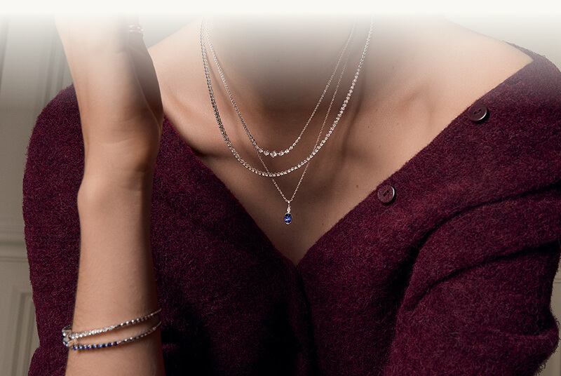 A woman close up, showcasing her beautiful Jewelries -  Necklaces, Bracelets.