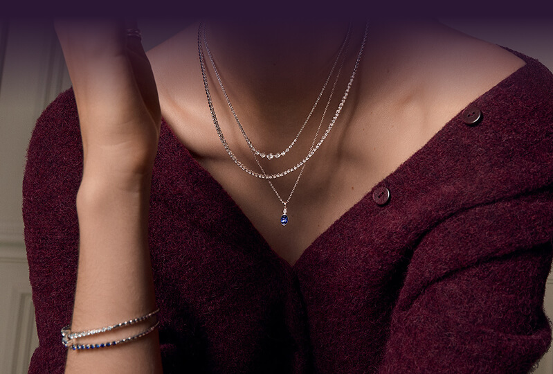 A woman close up, showcasing her beautiful Jewelries -  Necklaces, Bracelets.