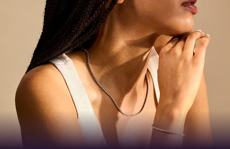 A model wearing various pieces of gemstone jewelry.