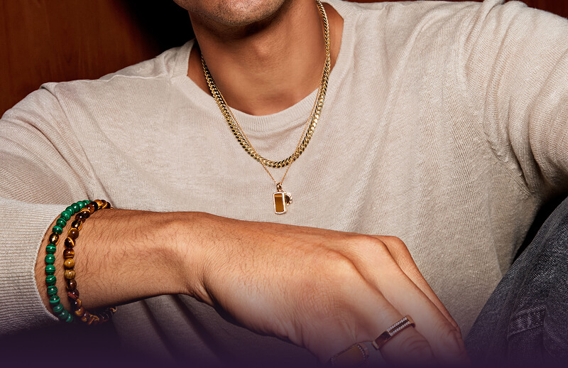 Male model wearring assortment of jewelry.