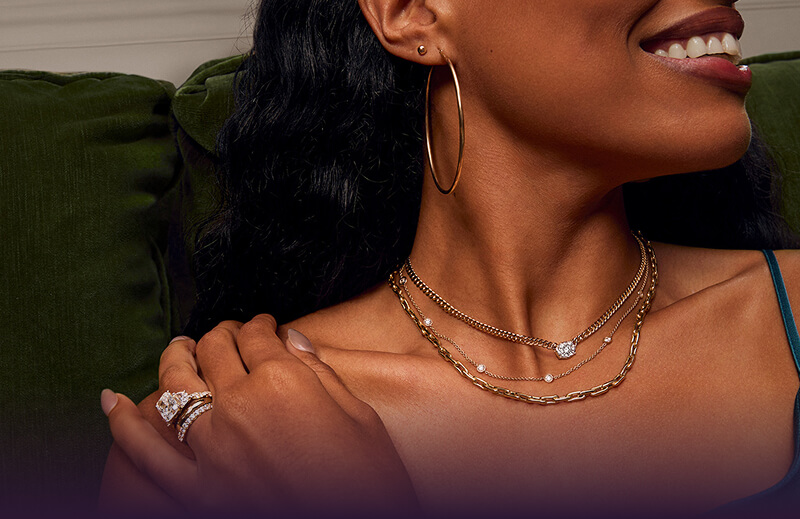 A smiling woman showcasing her beautiful Necklaces, Rings and Earrings. 