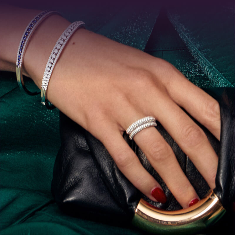 Model’s hand with bracelets and rings.