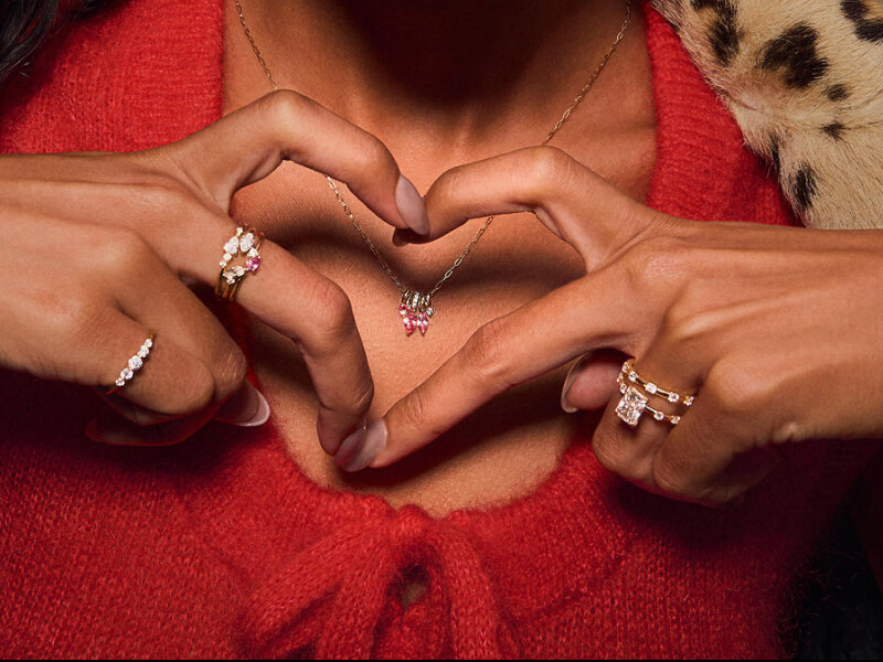 Model making heart sign wearing diamond and gemstones jewelry. 