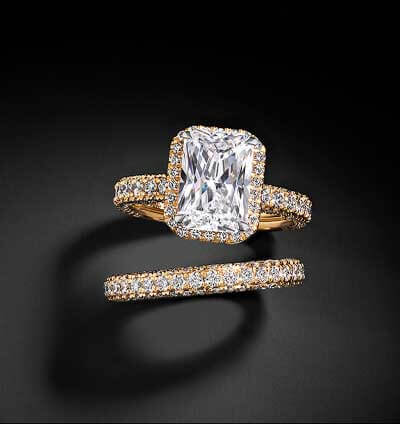 A radiant-cut center stone, on a warm gold, diamond band. Paired with a matching band.