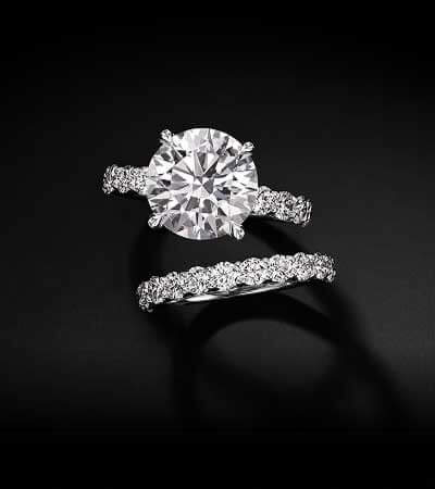 Round brilliant-cut stone on diamond band, paired with singular diamond band.