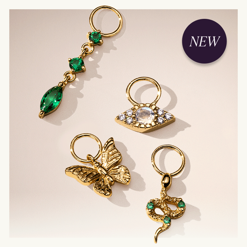 Badge reads ‘NEW.’ Rotating image of interchangeable gold charms, each unique with design-shapes & stone elements.
