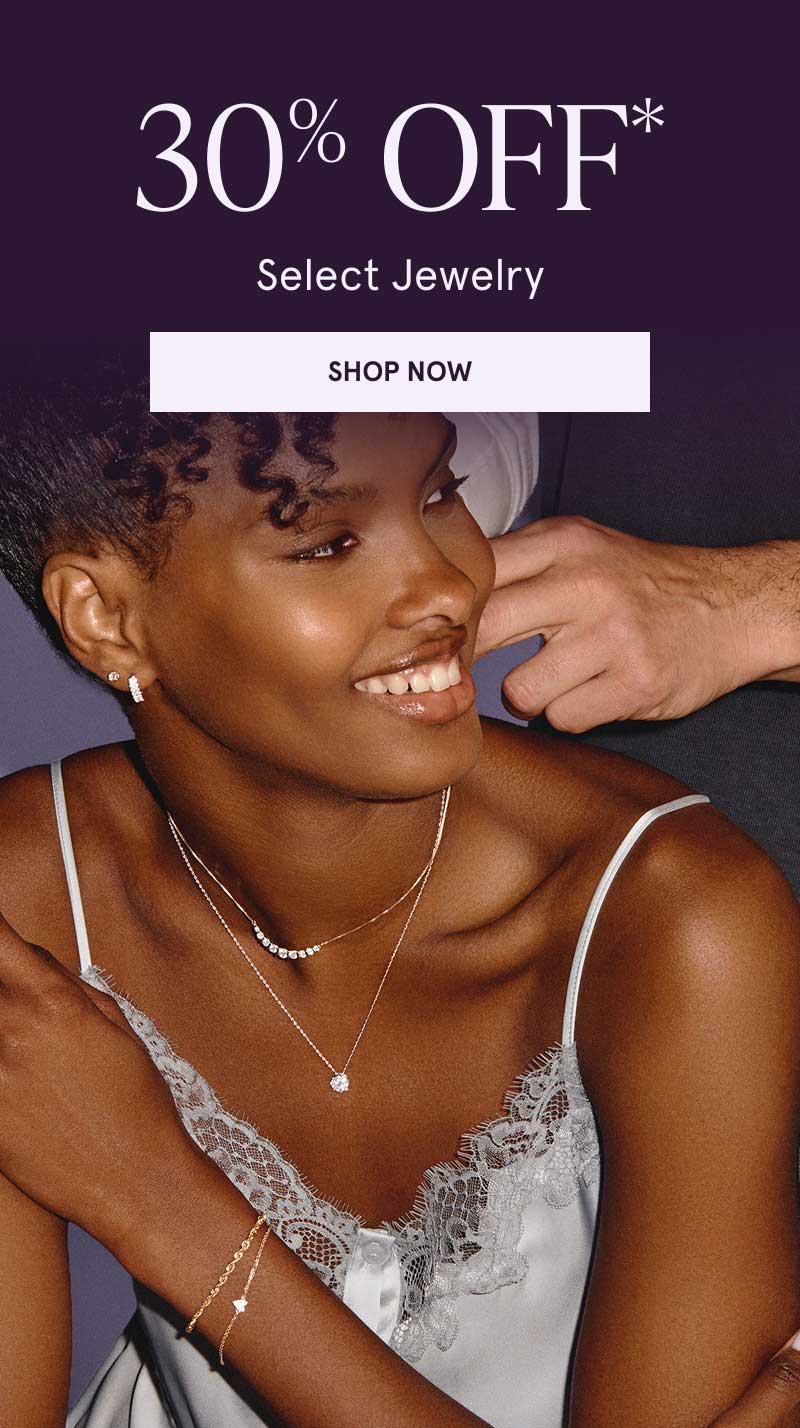 Model layered in gold-set jewelry with dainty diamond accents, including diamond pear-shaped ring. 30% OFF Select Jewelry. Click here to shop now