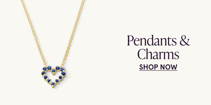 A gold necklace with a heart shaped, blue gemstone pendant. Click here to shop pendants and charms